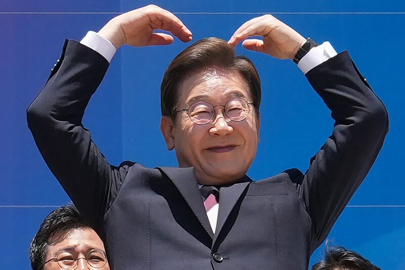 South Korea's President Lee Jae-myung makes a heart gesture to the people outside the National Assembly as he leaves following the inauguration ceremony in Seoul on June 4, 2025.